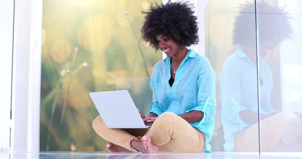 Mulher negra usando computador portátil no chão — Fotografia de Stock