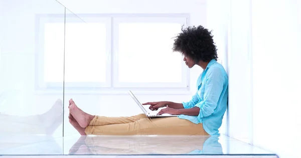 Чернокожая женщина с ноутбуком на полу — стоковое фото