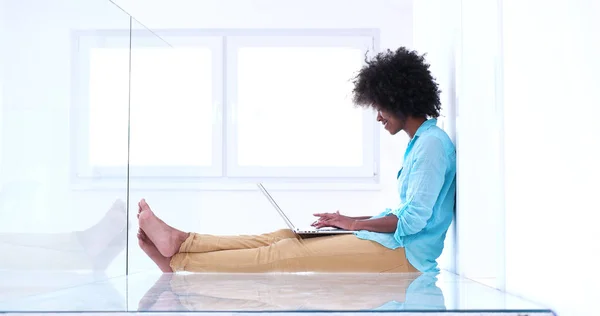 Чернокожая женщина с ноутбуком на полу — стоковое фото