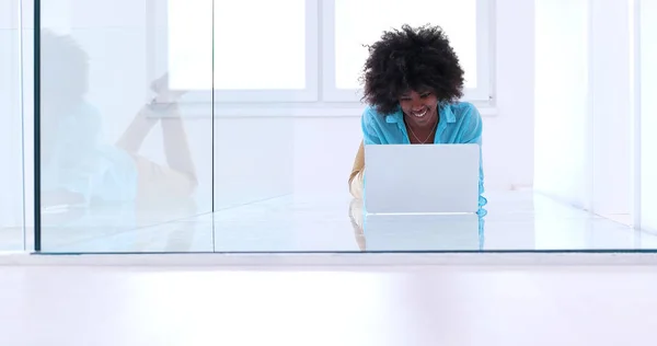 Mulher negra usando computador portátil no chão — Fotografia de Stock