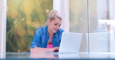 genç kadın yerde dizüstü bilgisayar kullanan