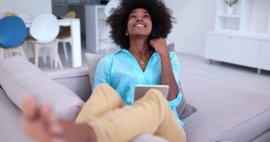 Afrikalı-Amerikalı kadın evde dijital tablet kullanma