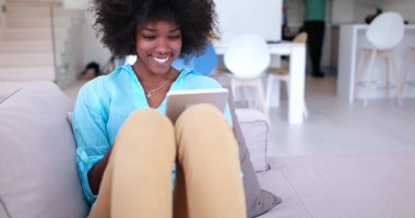 Afrikalı-Amerikalı kadın evde dijital tablet kullanma