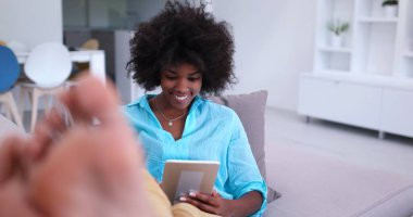 Afrikalı-Amerikalı kadın evde dijital tablet kullanma
