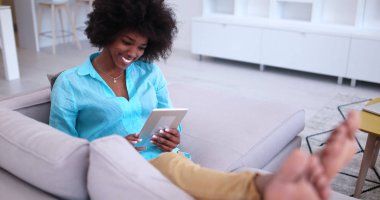 Afrikalı-Amerikalı kadın evde dijital tablet kullanma