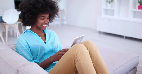 Mujer afroamericana en casa usando tableta digital —  Fotos de Stock