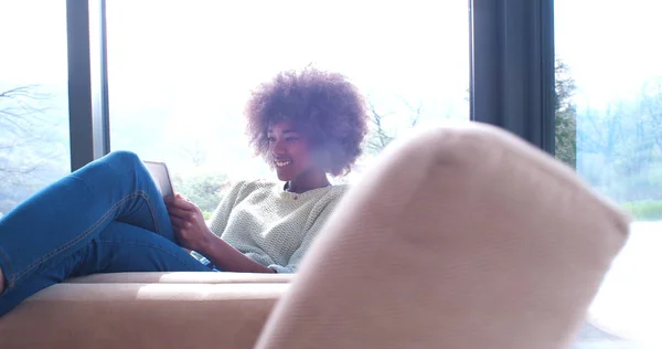 Mulher afro-americana em casa usando tablet digital — Fotografia de Stock