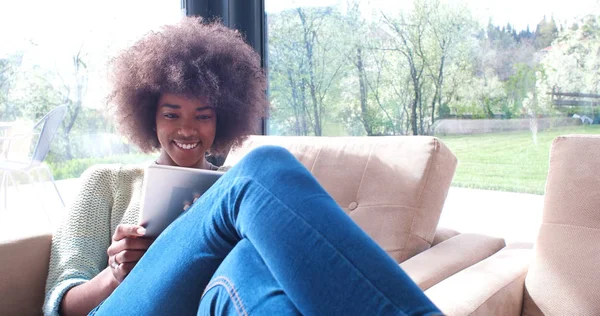 Femme afro-américaine à la maison en utilisant une tablette numérique — Photo