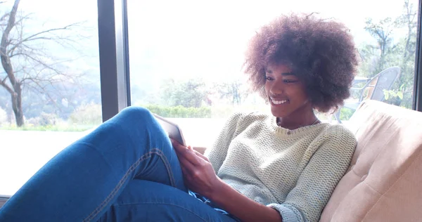 Mujer afroamericana en casa usando tableta digital —  Fotos de Stock