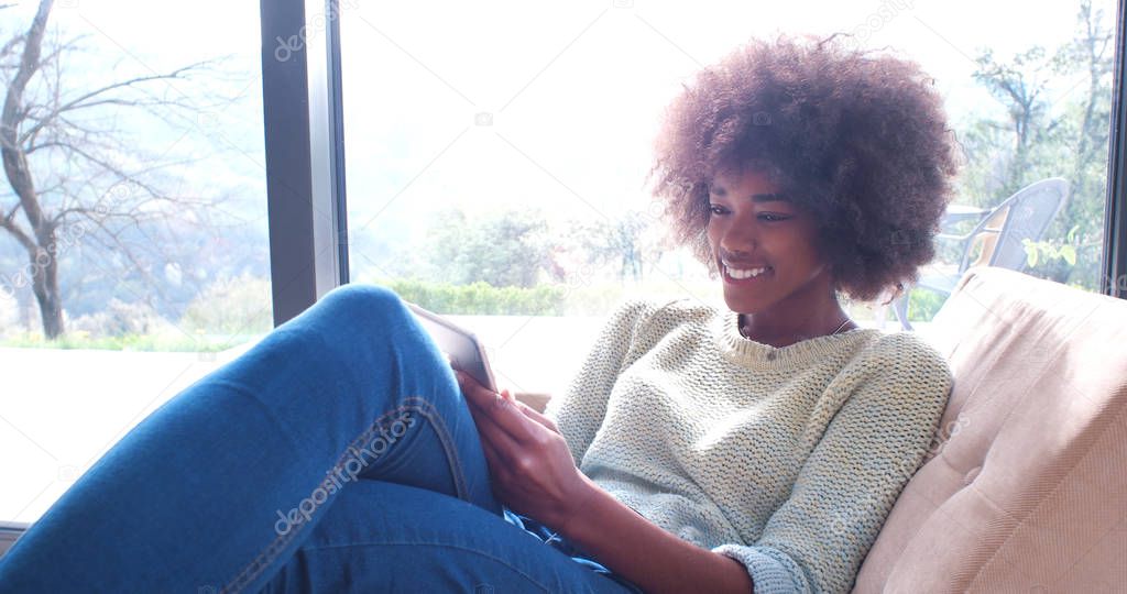 african american woman at home using digital tablet
