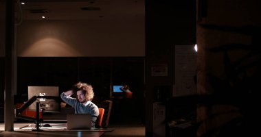 karanlık ofisinde bilgisayarda çalışan adam