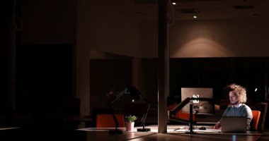 karanlık ofisinde bilgisayarda çalışan adam