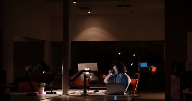 karanlık ofisinde bilgisayarda çalışan adam