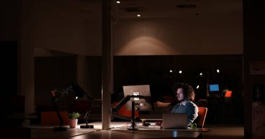 karanlık ofisinde bilgisayarda çalışan adam