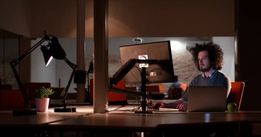 karanlık ofisinde bilgisayarda çalışan adam