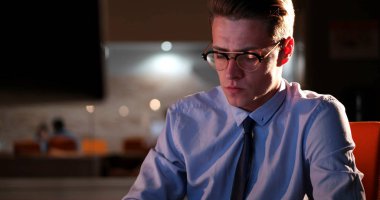 karanlık ofisinde bilgisayarda çalışan adam