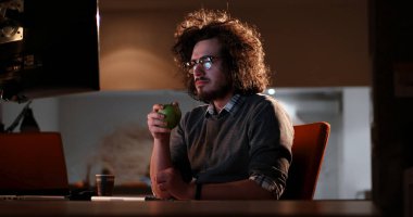 karanlık ofisinde bilgisayarda çalışan adam