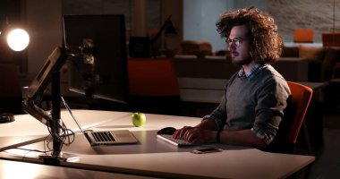 karanlık ofisinde bilgisayarda çalışan adam