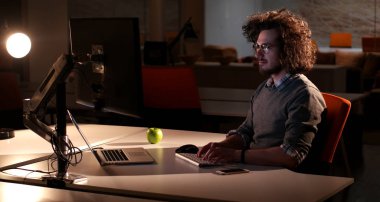 karanlık ofisinde bilgisayarda çalışan adam