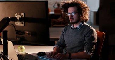 karanlık ofisinde bilgisayarda çalışan adam