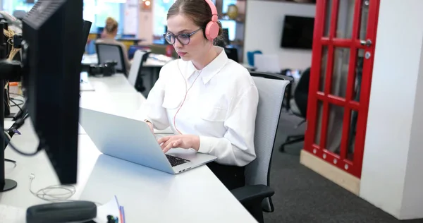 Empresária usando um laptop no escritório de inicialização — Fotografia de Stock
