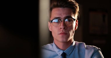 karanlık ofisinde bilgisayarda çalışan adam