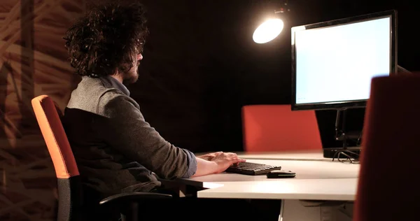 Hombre trabajando en la computadora en la oficina oscura —  Fotos de Stock