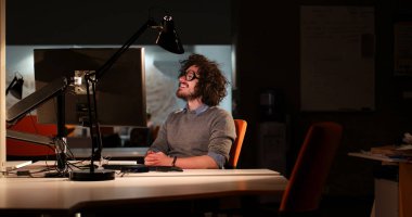 karanlık ofisinde bilgisayarda çalışan adam