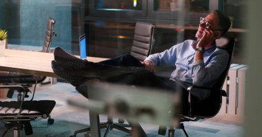 ayaklı ofis masasında oturan işadamı