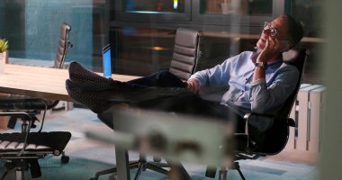 ayaklı ofis masasında oturan işadamı