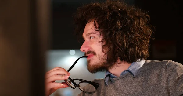 Mann arbeitet im dunklen Büro am Computer — Stockfoto