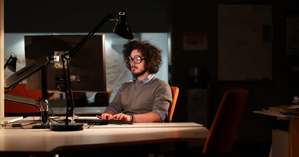 Hombre trabajando en la computadora en la oficina oscura — Foto de Stock