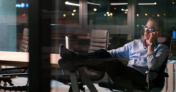 Homme d'affaires assis avec les jambes sur le bureau au bureau — Photo