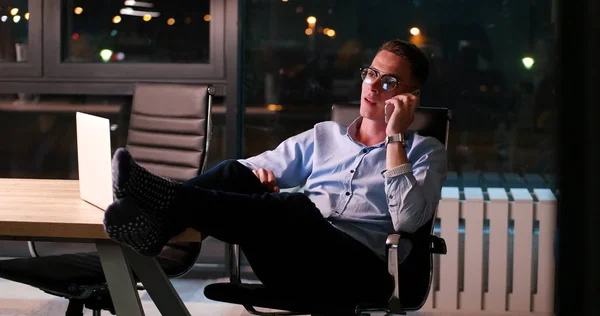 Podnikatel, sedí s nohama na stole v kanceláři — Stock fotografie