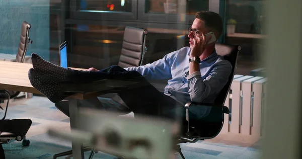 Zakenman zittend met benen op Bureau op kantoor — Stockfoto