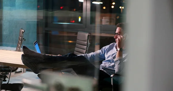 Uomo d'affari seduto con le gambe sulla scrivania in ufficio — Foto Stock