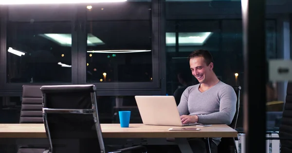 Mann arbeitet im dunklen Büro am Laptop — Stockfoto