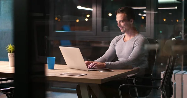 Man aan het werk op laptop in donkere kantoor — Stockfoto