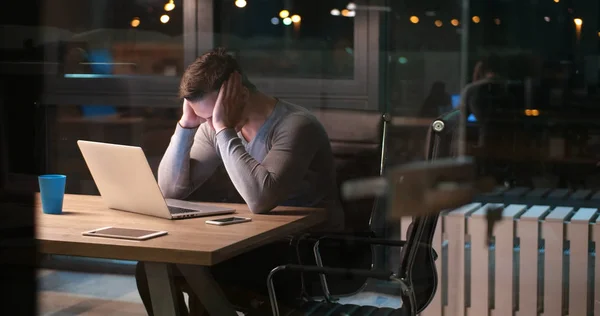 Man som arbetar på laptop i mörka office — Stockfoto