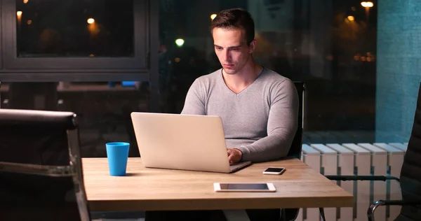 Man aan het werk op laptop in donkere kantoor — Stockfoto