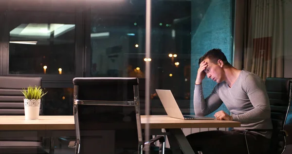 Hombre trabajando en el ordenador portátil en la oficina oscura — Foto de Stock