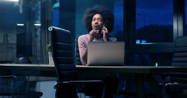 siyah işkadını gece başlangıç ofisinde bir dizüstü bilgisayar kullanarak