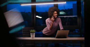 siyah işkadını gece başlangıç ofisinde bir dizüstü bilgisayar kullanarak