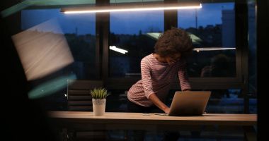 siyah işkadını gece başlangıç ofisinde bir dizüstü bilgisayar kullanarak