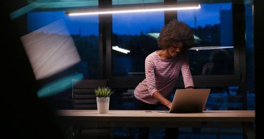 siyah işkadını gece başlangıç ofisinde bir dizüstü bilgisayar kullanarak