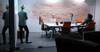 Bir grup genç iş adamı modern ofis binasında iş planlarını tartışıyor