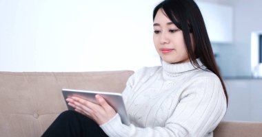 Asyalı kadın kanepede dijital Tablet kullanma