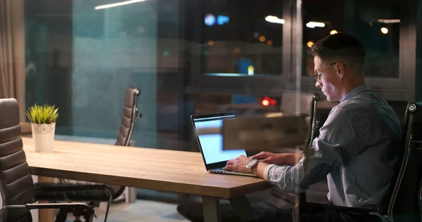 Man aan het werk op laptop in donkere kantoor — Stockfoto