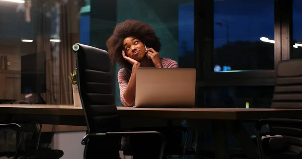 Black businesswoman using a laptop in night startup office — Stock Photo, Image
