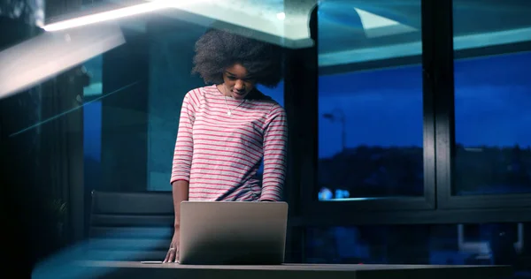 Mulher de negócios preta usando um laptop no escritório de inicialização da noite — Fotografia de Stock